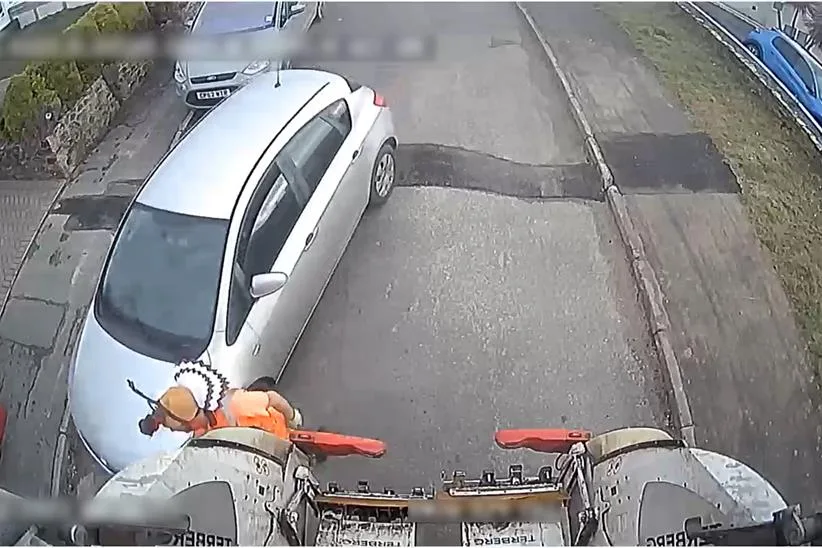 Un passage serré autour d'un camion de poubelle