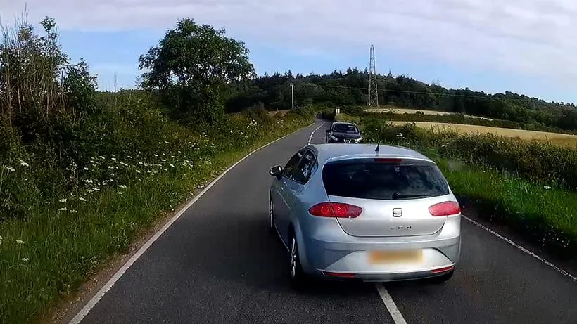 Une voiture fait un dépassement dangereux sur une route Une voiture fait un dépassement dangereux sur une route