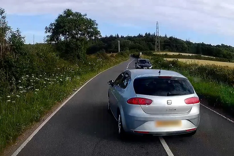Une voiture fait un dépassement dangereux sur une route